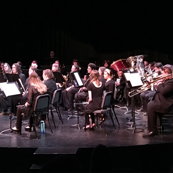 An orchestra performs on stage.