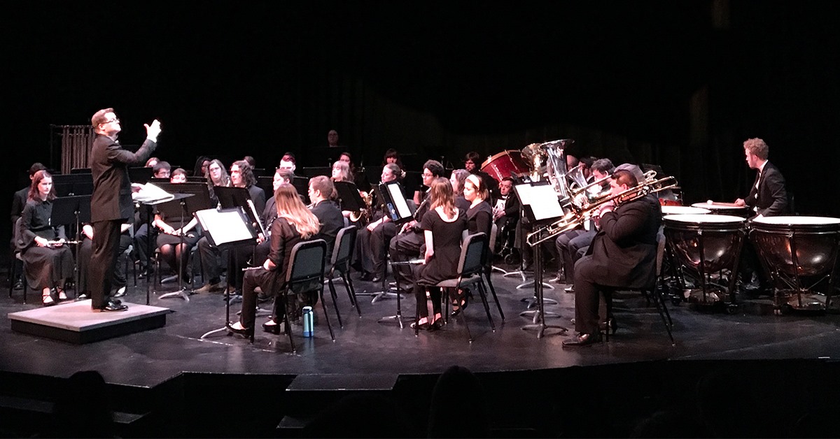 An orchestra performs on stage.