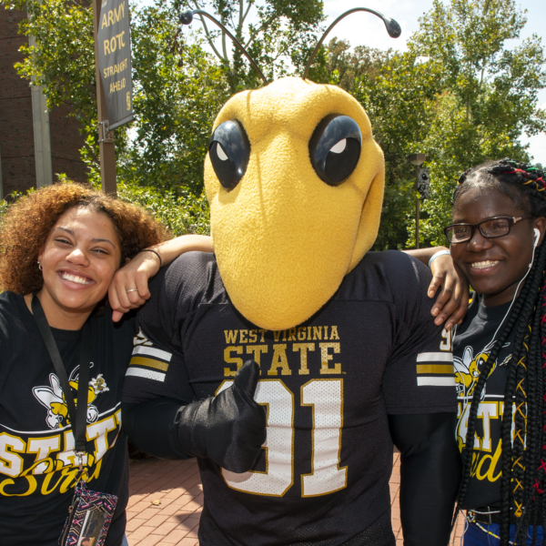 WVSU mascot Stinger poses with students