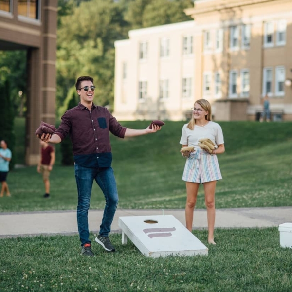 Students Play a Bean Bag Toss Game on the Campus Quad