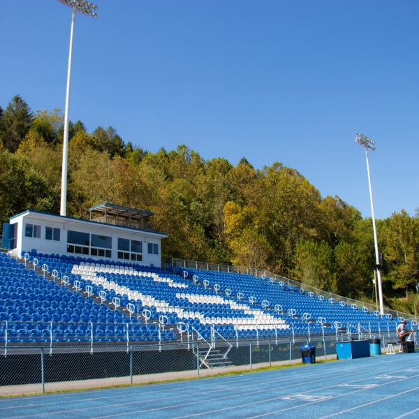 A view of the campus football stadium, which is saturated with blue and white. A large "G" is formed in the center of the bleachers, made to stand out by painting some chairs white and others bright blue. A bright blue track surrounds the field.